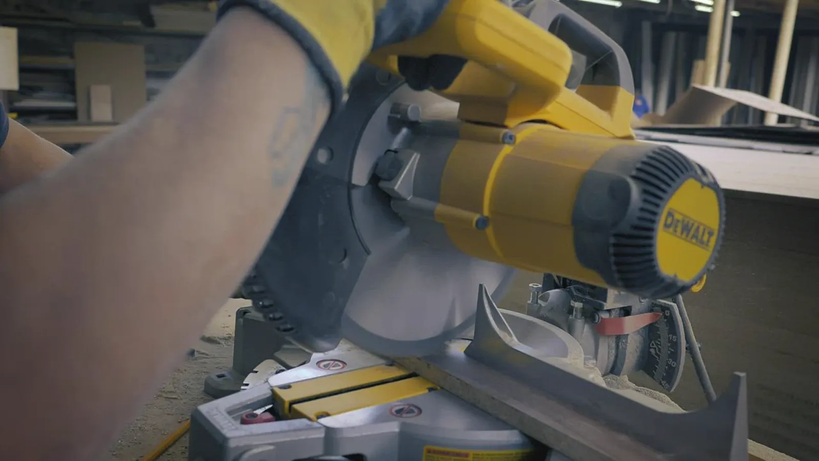 Worker cutting trim stock on a miter saw